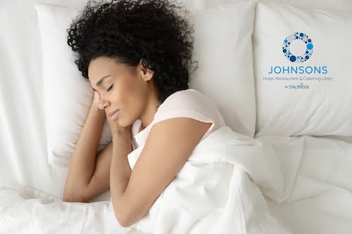 http://Lady%20sleeping%20in%20white%20linen%20and%20resting%20her%20head%20on%20a%20pillow